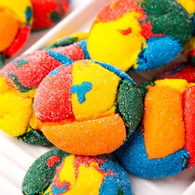 square image of rainbow cake mix cookies piled on a plate