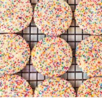 rows of rainbow sprinkle cookies on a wire rack with recipe name at the bottom