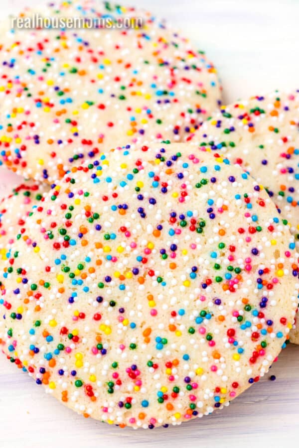 close up of a rainbow sprinkle cookie laid on other cookies