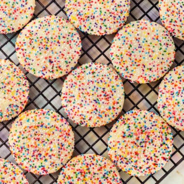 square image of rainbow sprinkle cookies on a wire cooling rack