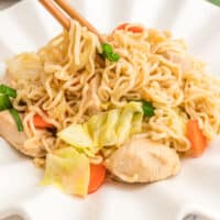plate of ramen noodle stir fry with chopsticks lifting a bite with recipe name at the bottom