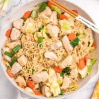 square imgae of ramen noodle stir fry in a skillet with chopsticks on the side