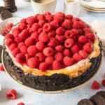 square image of a whole raspberry cheesecake on a cake stand