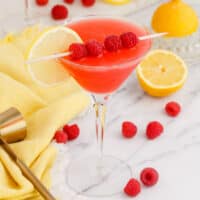 square image of a raspberry lemon drop martini next to fresh fruit and a jigger