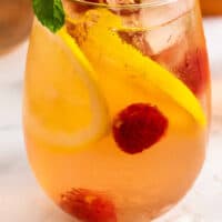 raspberry lemonade moscato sangria in a stem less wine glass with recipe name at bottom