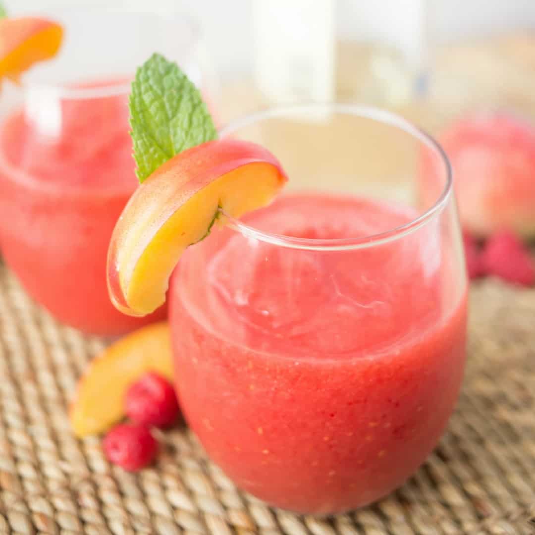 Raspberry Peach Wine Slushie is perfect for summer sipping! Just a few simple ingredients and you'll be enjoying a frozen wine cocktail in minutes!