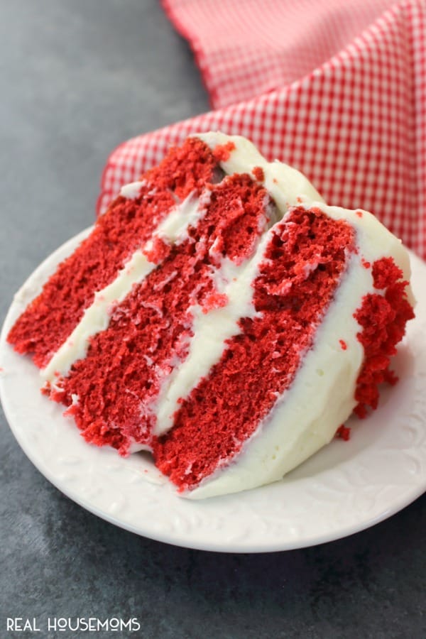 A slice of red velvet cake on a serving plate ready to be eaten