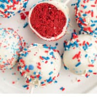 red velvet cake pops on a plate with a bite taken out of one to show the inside with recipe name at the bottom