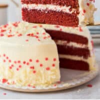 slice of red velvet cake on a cake server over the cake with recipe name at the bottom