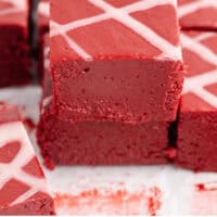 red velvet fudge square stacked up with recipe name at the bottom