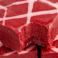 close up of a red velvet fudge square with a bite taken out to show the texture with the text of the post on top of the image in red and black lettering