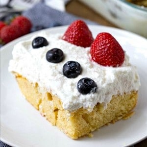 Red, White and Blue Cheesecake Poke Cake is a super easy dessert recipe that is perfect for celebrating the Fourth of July!