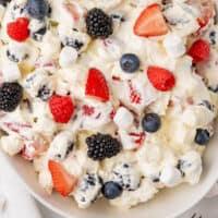 looking down at a bowl of red white and blue cheesecake salad with recipe name at the bottom
