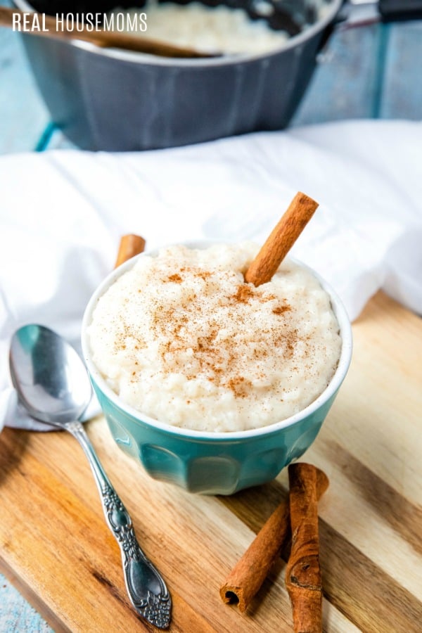 rice pudding a bowl with garnished is ground cinnamon and a cinnamon stick
