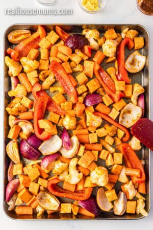 veggies seasoned with curry paste spread out on a baking sheet