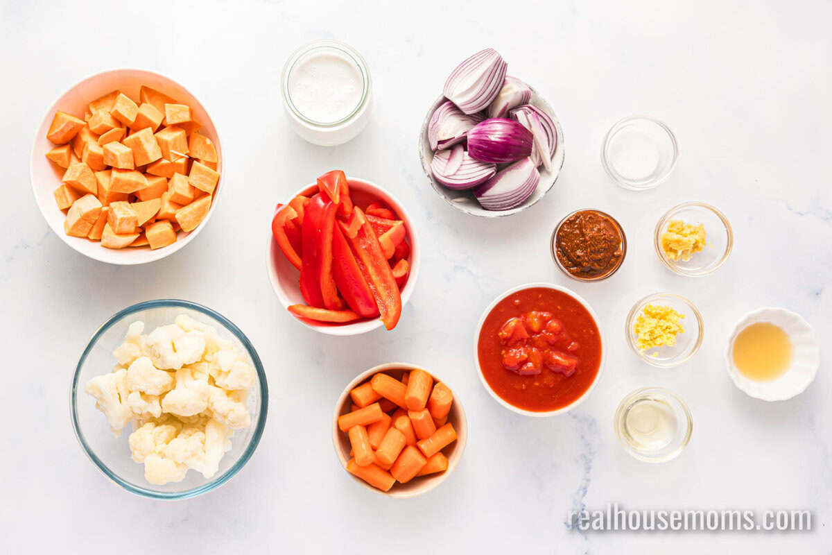 looking down at ingredients to make roasted vegetable curry in bows on a counter