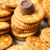 image of rolo stuffed ritz crackers arranged on a plate with a rolo on top of the center treat, with the title of the post on top in pink and black lettering