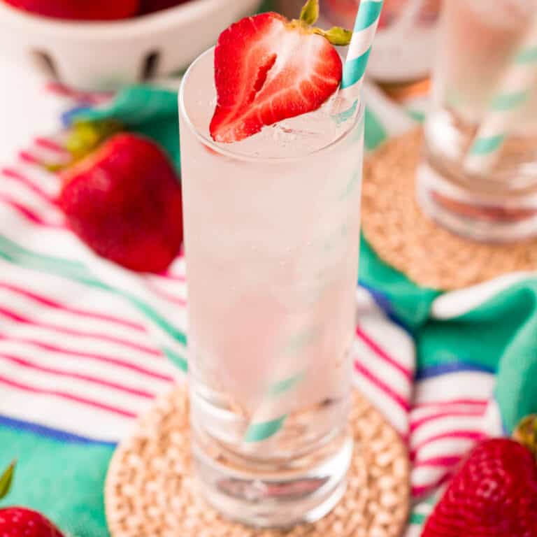 square image of a rose wine spritzer on a coaster with a straw