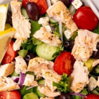 image of a salmon salad in a bowl with the title of the post on top of the image in pink and black lettering