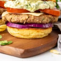 salsa verde turkey burger on a wooden board with recipe name at the bottom
