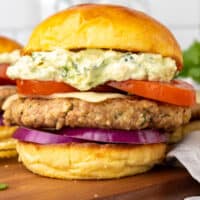 square image of a salsa verde turkey burger on a wooden board