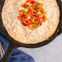looking down at a skillet of sausage cream cheese dip with recipe name at the bottom