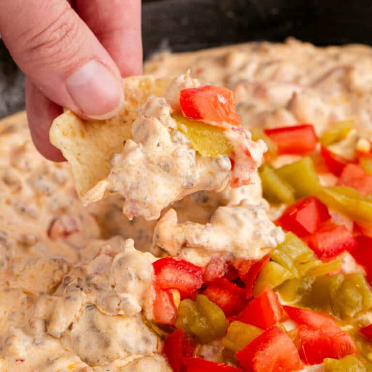square image of a tortilla chips dipped in sausage cream cheese dip