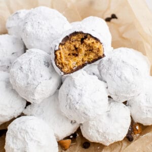 square image of scotcheroo truffles in a bowl with a bite taken out of onwe