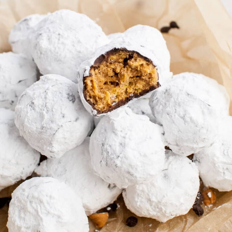 square image of scotcheroo truffles in a bowl with a bite taken out of onwe