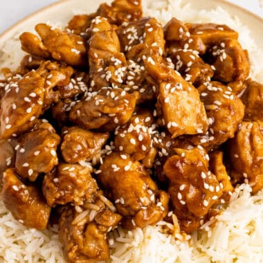 square image of sesame chicken served over rice