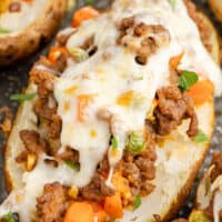 close up image of shepherd's pie baked potato on a baking sheet with the title of the post on top of the image in green and black lettering