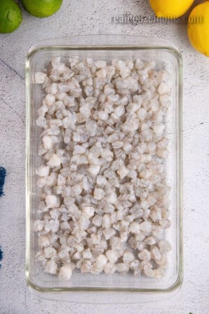 raw shrimp cut into small ,uniform pieces in a glass baking dish