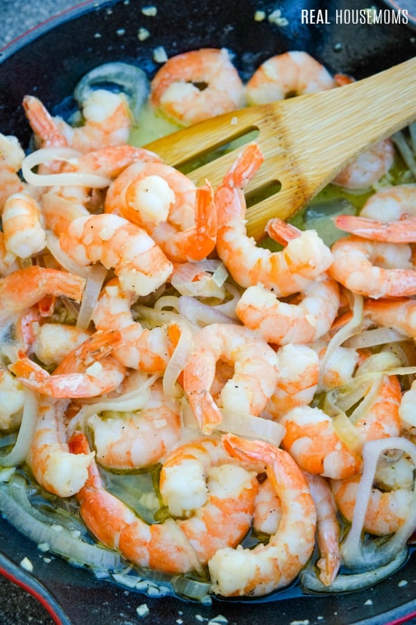 shrimp being cooked in a skillet to make shrimp scampi