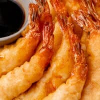 image of shrimp tempura arranged on a plate next to a bowl of dipping sauce, title of the post on top of image in orange and black lettering