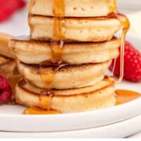 syrup being poured over a stack of silver dollar pancakes with recipe name at the bottom