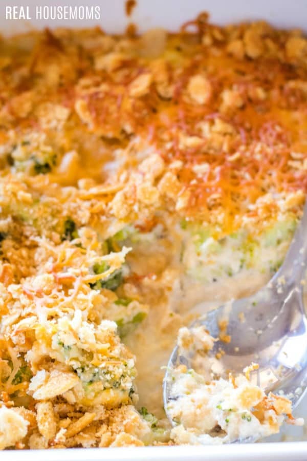 close up of baking dish with easy broccoli casserole and a serving spoon
