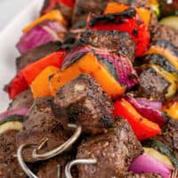 picture of sirloin shish kabobs piled on a paltter. With the title of the post on the top of picture in pink and black lettering