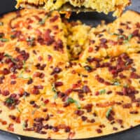 slice of pancetta corn casserole over the skillet with recipe name at the bottom