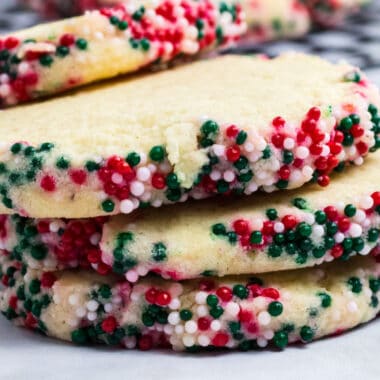square image of slice and back sugar cookies with Christmas sprinkles