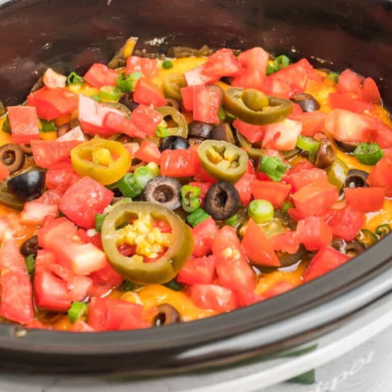 square image of slow cooker 7 layer chili cheese dip in a crock pot