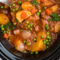 ladle in slow cooker beef stew with recipe name at the bottom