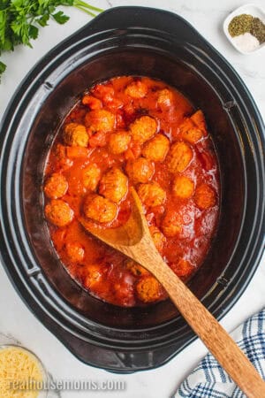 cooked meatballs in pasta sauce in a crock pot