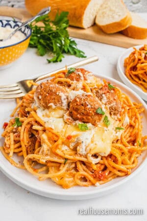 plate of slow cooker cheesy spaghetti and meatballs with a fork