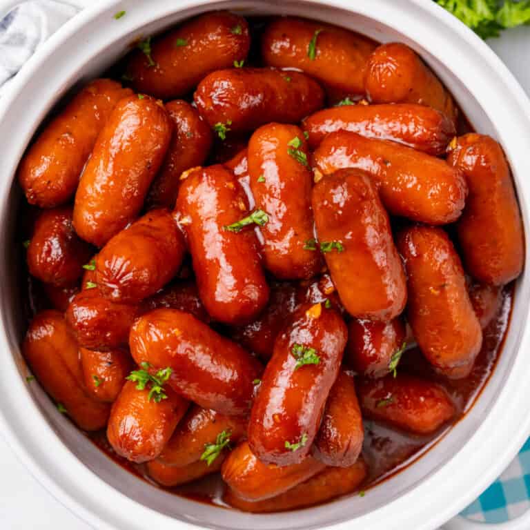 square image of slow cooker honey garlic lil' smokies topped with chopped parsley