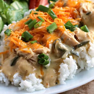 square image of Slow Cooker Poblano Chicken over rice with cheese and green onions on top