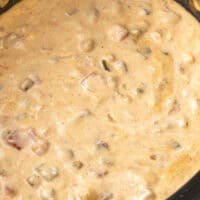 angled view of slow cooker queso dip in a crock pot with the title of the post on top in blue and black lettering