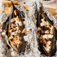square image of two s'mores campfire banana boats on the foil after being unwrapped