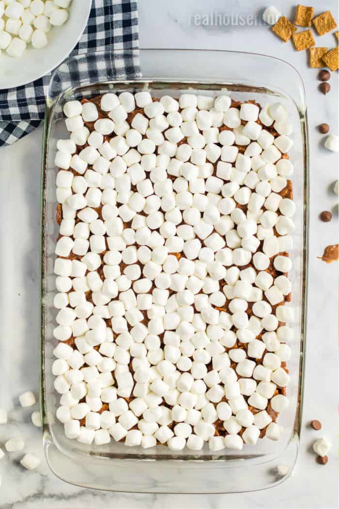 mini marshmallows spread over chocolate golden grahams in a baking dish