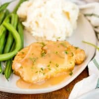Smothered Fried Pork Chops are classic Southern food! Breaded fried pork chops are smothered in pan gravy and served with your favorite Sunday supper sides!