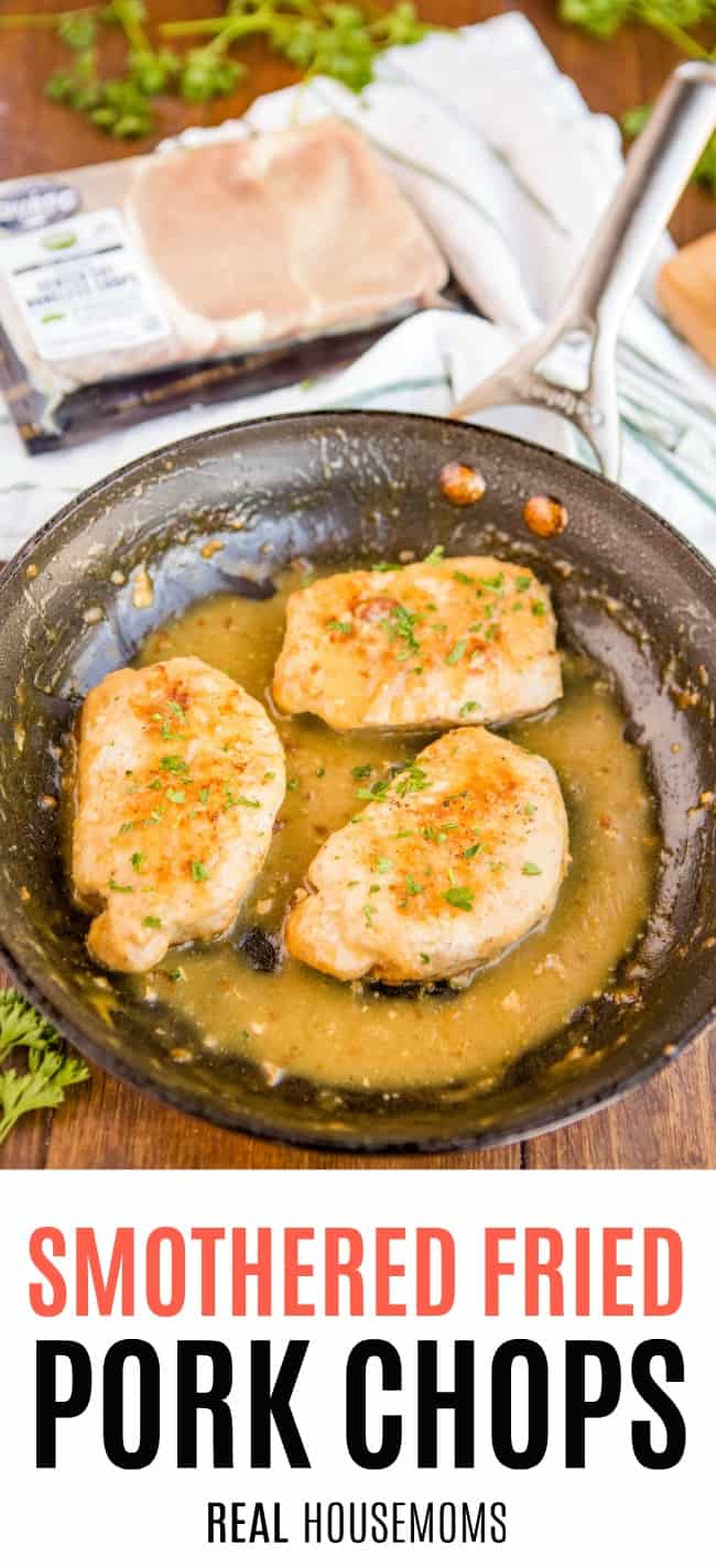 smothered fried pork chops in a skillet with sauce